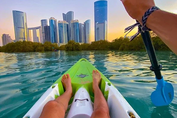 Kayaker at Reem Island at sunset with the Abu Dhabi city skyline in the background