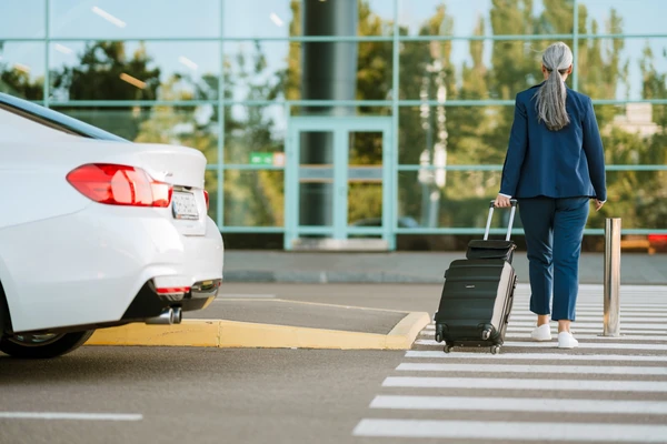 Traveller with luggage meeting a private airport transfer vehicle