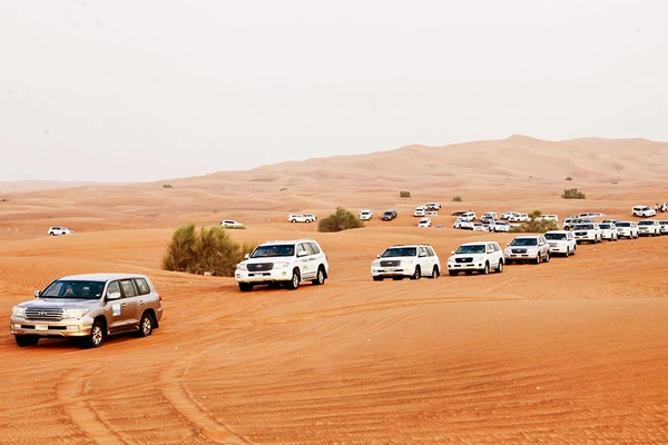 Convoy of four-wheel-drive vehicles crossing the Abu Dhabi desert during a holiday tour