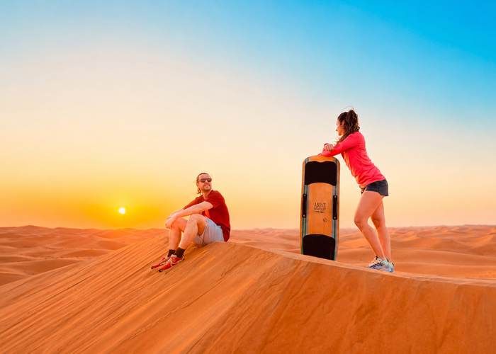 Couple on top of a dune in the Abu Dhabi desert at sunset