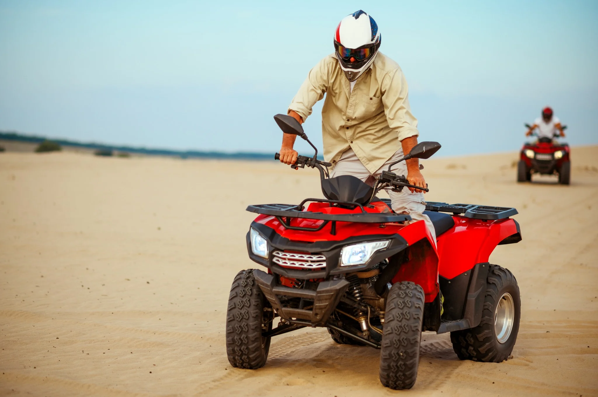 Close view of a rider on a red quad bike in the Abu Dhabi desert