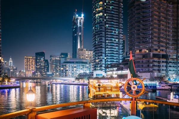Traditional dhow and Dubai Marina skyline at night during a private Dubai city tour