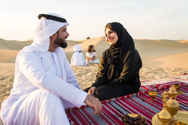 Family relaxing together on the dunes during an Abu Dhabi evening desert safari