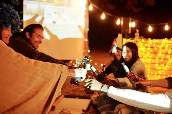 Guests relaxing together at a lit desert camp during a Liwa overnight camping experience