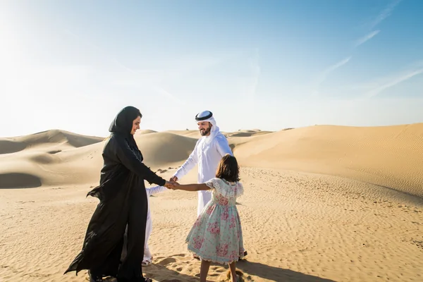 Emirati family walking together across the Liwa dunes during a private desert day tour from Abu Dhabi
