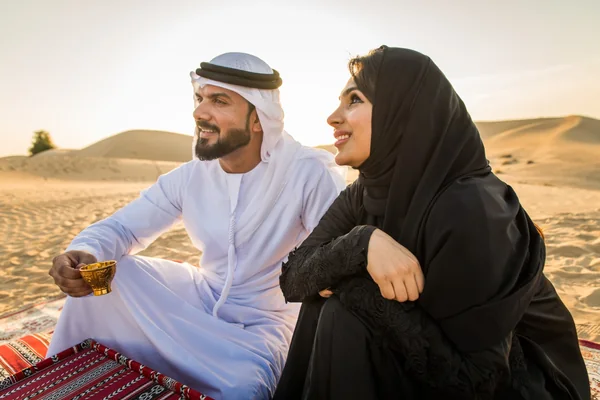 Emirati couple relaxing with Arabic coffee in the morning desert near Abu Dhabi