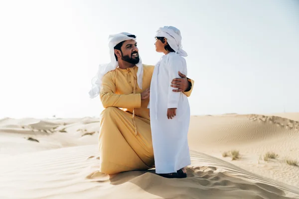 Emirati father and child together on the dunes during a family morning desert safari near Abu Dhabi