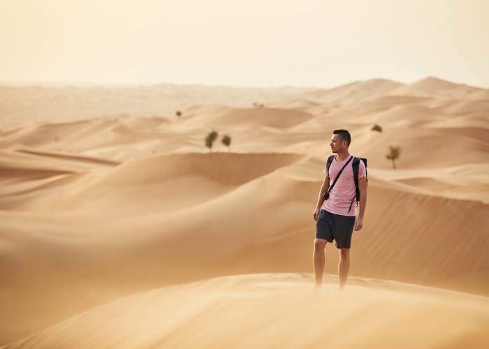 Traveller standing on a dune in the cool morning light near Abu Dhabi