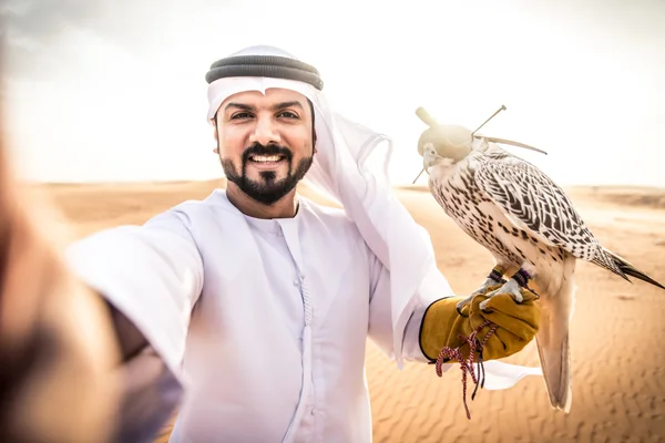 Emirati couple taking a selfie on a traditional boat during a UAE holiday